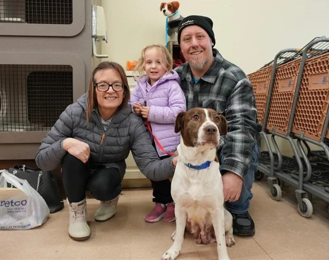 Family with a dog at a community adoption event