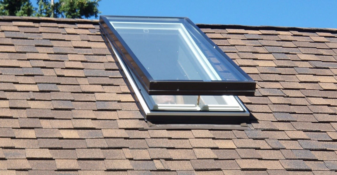 A skylight installed in a shingled roof